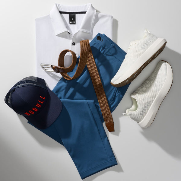 White polo shirt, blue pants, white sneakers, navy cap, and brown belt on a light gray background