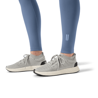 Women's Dusty Blue U High-Rise Matte Tight 28" Logo and Footwear Angle.